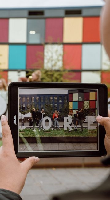 Student schießt mit einem Tablet ein Bild von unserem CORE Emblem